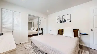 a white bedroom with a bed and a mirror at Jackson's Alpine Retreat - For 4 in Mammoth Lakes