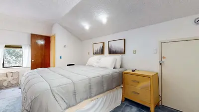 a bedroom with a large bed and a wooden dresser at Cozy Condo for 4 Near Shuttle & Eagle Lodge in Mammoth Lakes