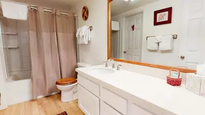 a bathroom with a sink and a toilet and a mirror at La Residence - Shared Pool Hot Tub & More in Mammoth Lakes