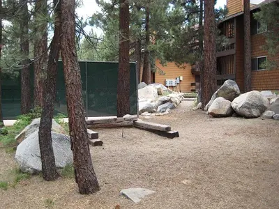 a yard with rocks and trees and a building at La Residence - Shared Pool Hot Tub & More in Mammoth Lakes
