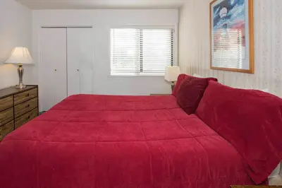 a bedroom with a large bed with a red blanket at La Vista Blanc #22 - Near Shuttle BBQ & Pool in Mammoth Lakes