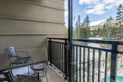 a balcony with chairs and a view of a mountain at 2 BDR Family Resort Condo with Pool Lounge & Mountain Views in Mammoth Lakes