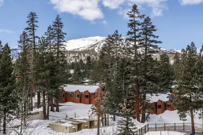a lodge in the snow with trees and a mountain at 2 BDR Family Resort Condo with Pool Lounge & Mountain Views in Mammoth Lakes