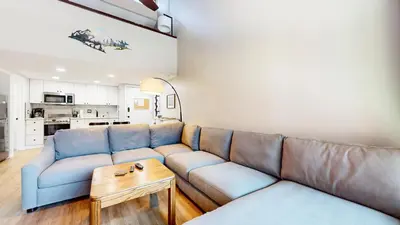 a living room with a couch and a table at Mammoth Getaway - Chic Condo in Mammoth Lakes