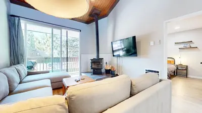 a living room with a couch and a tv at Mammoth Getaway - Chic Condo in Mammoth Lakes