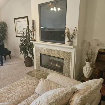 a living room with a fireplace with a tv above it at Waterfront Elegance in Discovery Bay