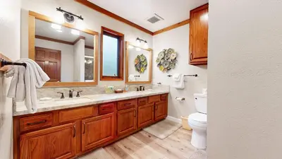 a bathroom with a sink and a toilet and a mirror at Mammoth Pines #02 - Year-Round Activities in Mammoth Lakes