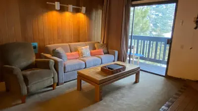 a living room with a couch and a coffee table at Mammoth Point #129 - Balcony with Mountain Views in Mammoth Lakes