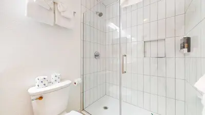 a white bathroom with a shower and a toilet at Cozy Cabin for 6 - Near Canyon Lodge & Slopes in Mammoth Lakes