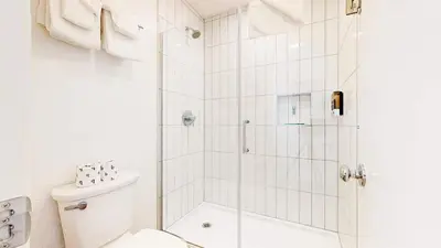 a white bathroom with a shower and a toilet at Cozy Cabin for 6 - Near Canyon Lodge & Slopes in Mammoth Lakes