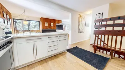a kitchen with white cabinets and a wooden floor at Cozy Cabin for 6 - Near Canyon Lodge & Slopes in Mammoth Lakes