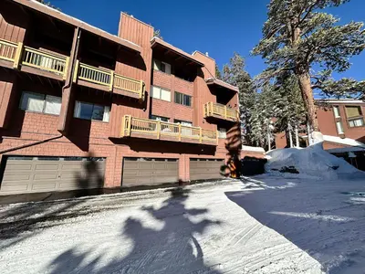 a person riding a snowboard in front of a building at Modern Cabin for Family of 8 - Near Slopes & Canyon Lodge in Mammoth Lakes