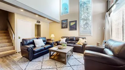 a living room with leather furniture and a table at Modern Cabin for Family of 8 - Near Slopes & Canyon Lodge in Mammoth Lakes
