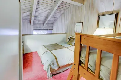 a small bedroom with a bed and a mirror at Mammoth Ski & Racquet with Shared Hot Tub & Pool in Mammoth Lakes