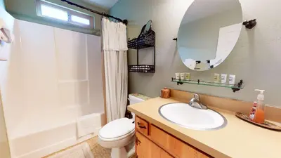 a bathroom with a sink and a toilet and a mirror at Mammoth View Villas - Near Hike & Bike Trails in Mammoth Lakes