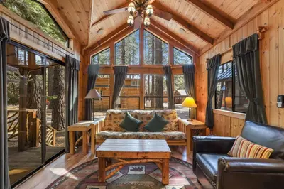 a living room with a couch and a table at The Cozy Cub Cabin 7 Min to Lake in South Lake Tahoe