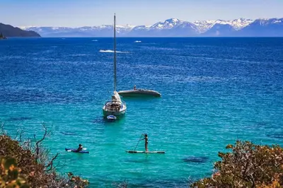 a sail boat and a person in the water at The Cozy Cub Cabin 7 Min to Lake in South Lake Tahoe