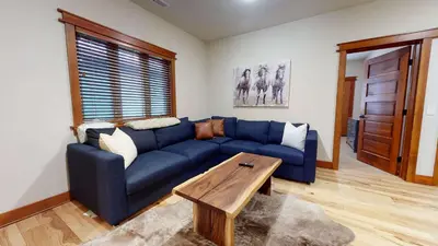 a blue couch in a living room with a table at Red Slate Canyon - Modern 2-Story Condo in Mammoth Lakes