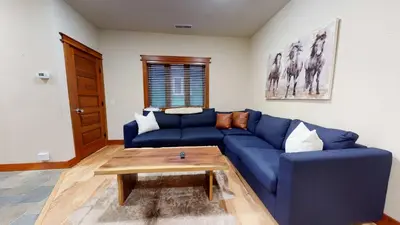 a blue couch in a living room with a coffee table at Red Slate Canyon - Modern 2-Story Condo in Mammoth Lakes