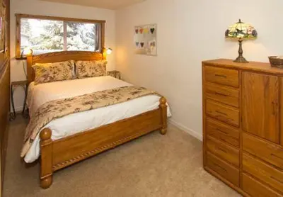 a bedroom with a bed with a dresser and a window at Mammoth View Villas - Shop Hike or Golf in Mammoth Lakes