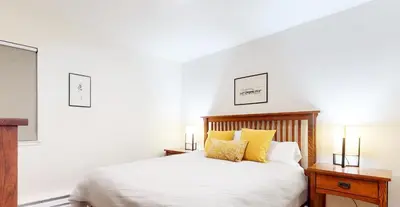 a bedroom with a bed with yellow pillows at Mid Century Modern Cabin #212 - Walk to Village in Mammoth Lakes