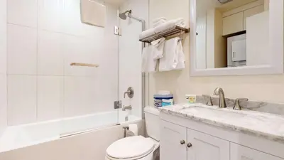 a bathroom with a toilet and a sink and a mirror at Mid Century Modern Cabin #212 - Walk to Village in Mammoth Lakes