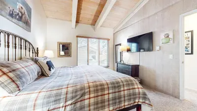 a bedroom with a bed and a flat screen tv at Mountain Chateau Retreat - Desirable Resort 4 BDR in Mammoth Lakes