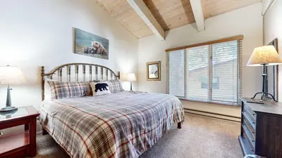 a bedroom with a bed and a tv and a window at Mountain Chateau Retreat - Desirable Resort 4 BDR in Mammoth Lakes