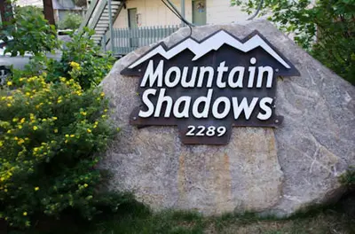 a sign for mountain shadows on a rock at Mountain Shadows #B08 - Near Hike Bike & Ski in Mammoth Lakes