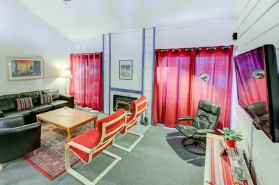 a living room with red curtains and a table and chairs at Mountain Shadows #B08 - Near Hike Bike & Ski in Mammoth Lakes