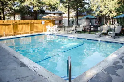 a swimming pool with blue water in a yard at Mountain Shadows #F02 - Near Shuttle & Shopping in Mammoth Lakes