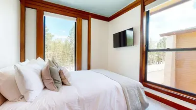 a bedroom with a white bed and a large window at Obsidian Dreaming - On the Sierra Star Golf Course in Mammoth Lakes