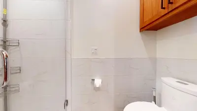 a white bathroom with a shower and a toilet at Obsidian Ski & Golf Villa - 3 BDR Prime Location in Mammoth Lakes