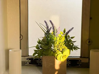 a vase with flowers in front of a mirror at The Magic Skoolie in Visalia