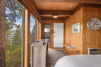 a bedroom with a large window and a clock on the wall at Stunning Views at Stargazer - Lakefront Studio in Crystal Bay