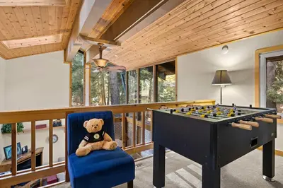a teddy bear sitting in a chair next to a pool table at Sundance - Foosball Table BBQ Near West Beach in Carnelian Bay