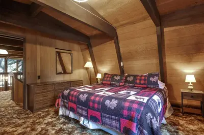 a bedroom with a bed and a wooden wall at Truckee Cabin Getaway - Sleeps 6 in Truckee