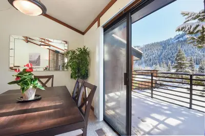 a dining room with a table and a balcony with a view at Valley View Bliss - Nearby Bike Trails & Beach in Olympic Valley