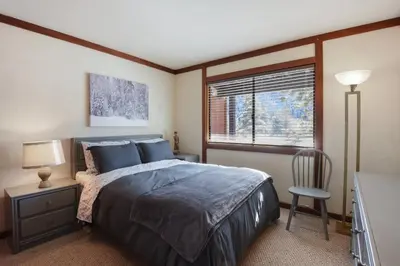 a bedroom with a bed and a chair and a window at Valley View Bliss - Nearby Bike Trails & Beach in Olympic Valley