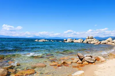 a beach with rocks and the ocean on a sunny day at Vista Point - 5 Minutes to Kings Beach in Tahoe Vista