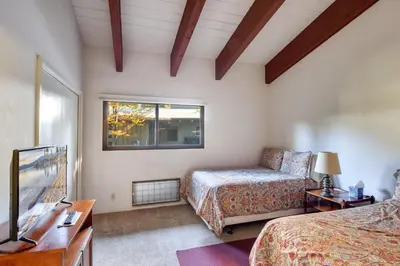 a bedroom with a bed and a couch and a window at Waters Edge Escape - Patio with BBQ Near Beach in Tahoma