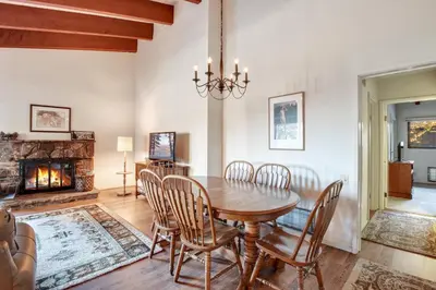 a dining room with a table and chairs and a fireplace at Waters Edge Escape - Patio with BBQ Near Beach in Tahoma