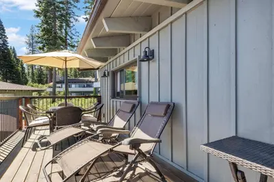 a group of chairs and an umbrella on a porch at Waters Edge Jewel with Lake Views - HOA Access in Tahoma