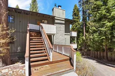 a home with a wooden staircase leading up to a house at Waters Edge Oasis - Shared Pool & Pier Access in Tahoma