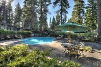 a pool with a table and an umbrella at Waters Edge Vista - HOA Pool & Pier Access in Tahoma