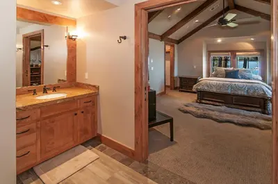 a bathroom with a sink and a bedroom with a bed at West Lake Serenity with 180-Degree Lake Views in Homewood