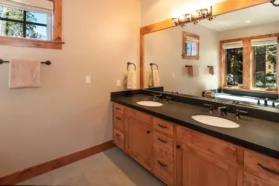 a bathroom with two sinks and a large mirror at West Lake Serenity with 180-Degree Lake Views in Homewood