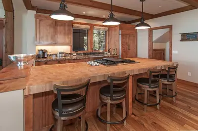 a kitchen with a large wooden island with bar stools at West Lake Serenity with 180-Degree Lake Views in Homewood