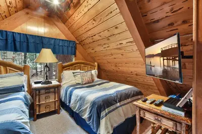 a bedroom with two beds in a log cabin at West Shore Haven - Near Beach & Outdoor Fun in Tahoma