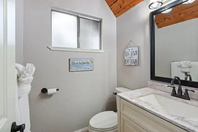 a bathroom with a toilet and a sink and a mirror at West Shore Haven - Near Beach & Outdoor Fun in Tahoma